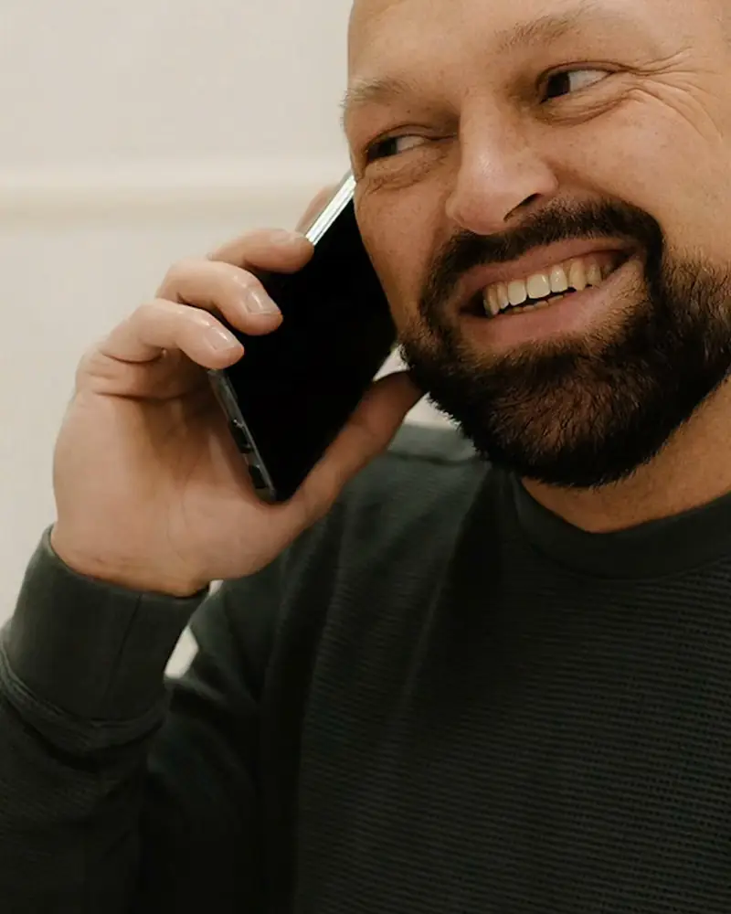 Henk lachend aan de telefoon